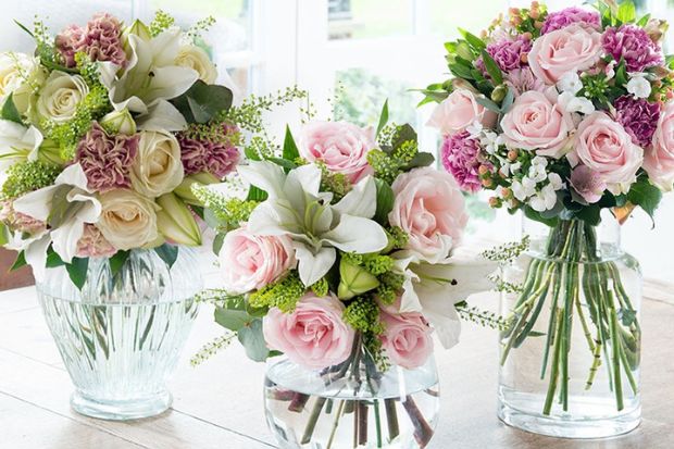 Three floral arrangements on a wooden table