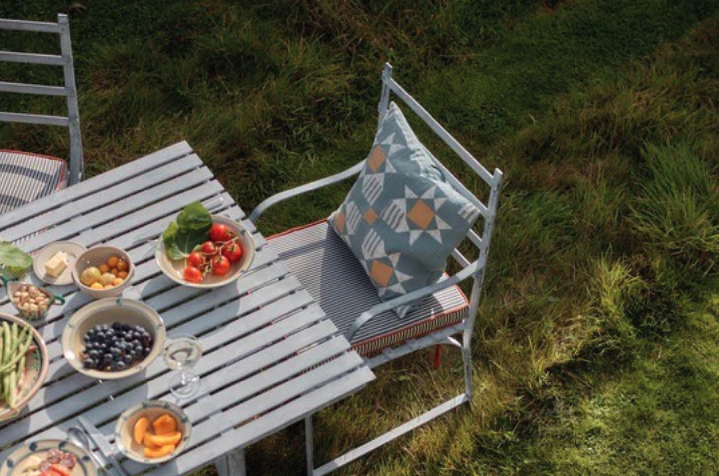 Rowen & Wren Sudbury Dining Table set up for an outdoor meal on grass