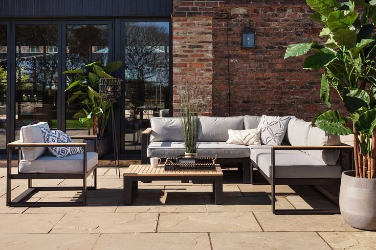 Barker and Stonehouse Azores Aluminum L-Shape Corner Garden Sofa and Chair Set with Table on a stone patio
