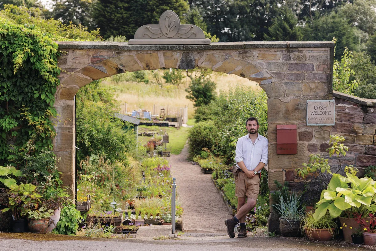 Dean Charlton at Hooton's Walled Nursery Man stood under garden stone archway